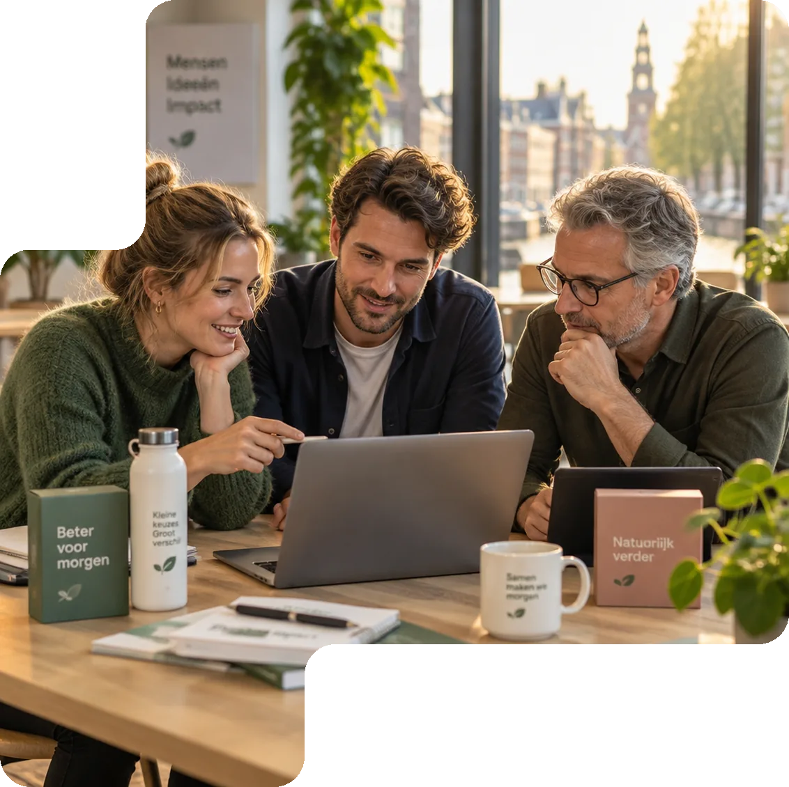 Drie collega's bekijken op een laptop hoe productdata centraal wordt beheerd voor meerdere merken
